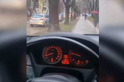 Vozač BMW bahato pretiče kolonu trotoarom dok ljudi prolaze