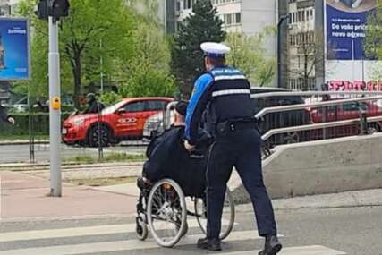 Policajac pomogao osobi u kolicima da pređe cestu